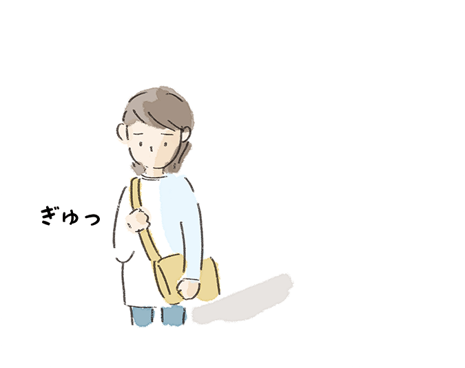 悲しそうにバッグをぎゅっと掴む姿